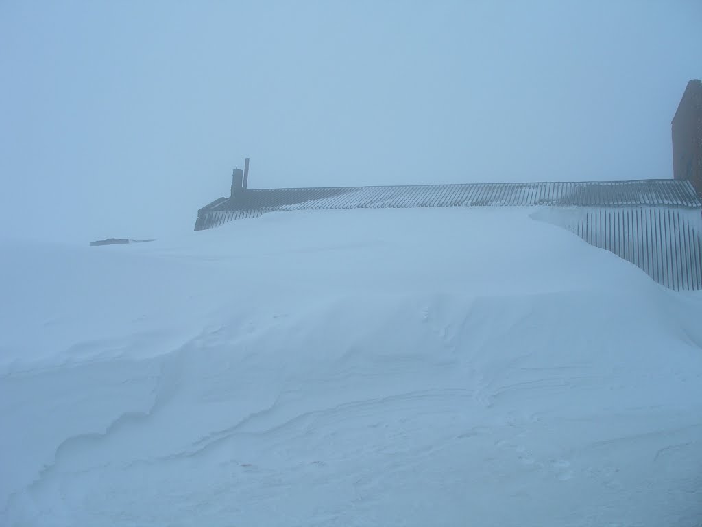 Left wing of Vega MS technical facility in blizzard, snow drifts against wall